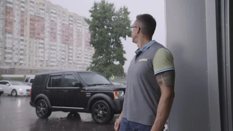 A man resents going out in the rain Stock Footage 94233497