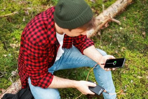 Man resolves a battery emergency and power shortage outdoors in a forest, c.. Stock Photos