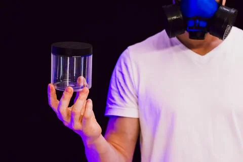 Man in respirator mask presenting empty jar Stock Photos