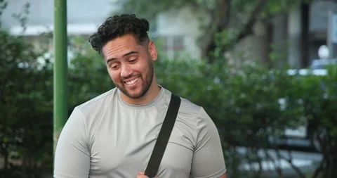 Man is responding to off-frame voice near green pole shifting to laughter while Stock Footage 340257325