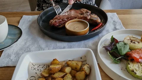 A man in a restaurant cuts a beef steak. Stock Footage 206325162