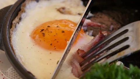 Man in restaurant eating scrambled eggs with bacon during breakfast Stock Footage 74734985