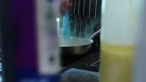 A man in a restaurant kitchen stirring a dish in a frying pan, steam goes Stock Footage 141029264