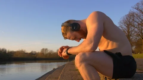 Man resting after long run, runner sitting down and catching breath  Stock Footage 85658638