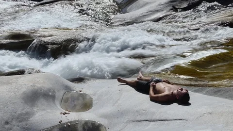 Man resting on alpine riverside Stock Footage 114177392
