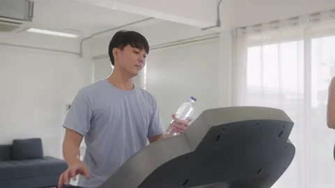 Man resting and drinking water in gym Video stock 248585414