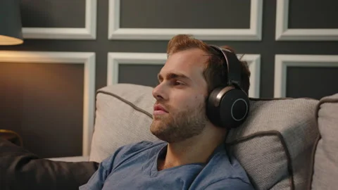 Man resting at couch with big headphone on Stock Footage 130297693