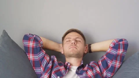 Man resting on the couch at home. hands behind his head Stock Footage 219549951