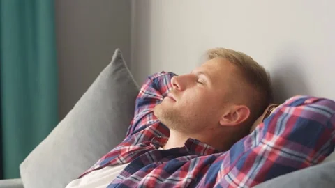 Man resting on the couch at home. hands behind his head Stock Footage 221398944