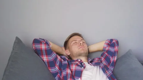 Man resting on the couch at home. hands behind his head Stock Footage 221399291