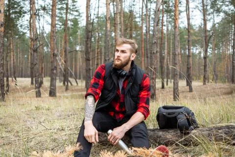 Man resting in the forest and drinking tea from the thermos Stock Photos