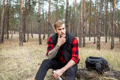 Man resting in the forest and drinking tea from the thermos Stock Photos