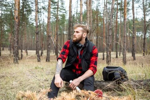 Man resting in the forest and drinking tea from the thermos Stock Photos