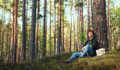 Man resting in a forest during a wild mushroom foraging trip. This outdoor .. Stock Photos