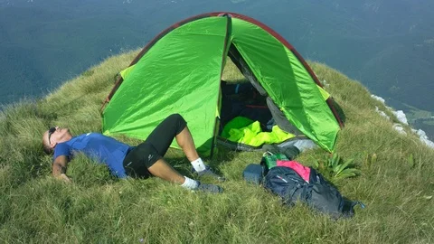 Man Resting In Front Of His Tent On High Ground Stock Footage 93661527
