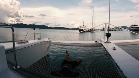 Man resting on the net of sailing catamaran Stock Footage 164921097