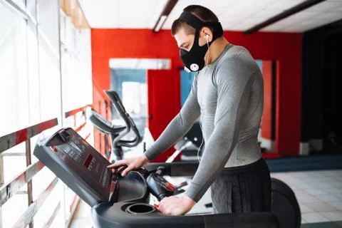 Man resting before the next race, doing sports, in a training mask for breath Stock Photos