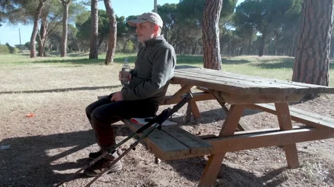 Man Resting Outdoors While Drinking Water on a Sunny Day Stock Footage 312537584