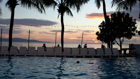 A man is resting in the pool on the sunset background Stock Footage 91807568
