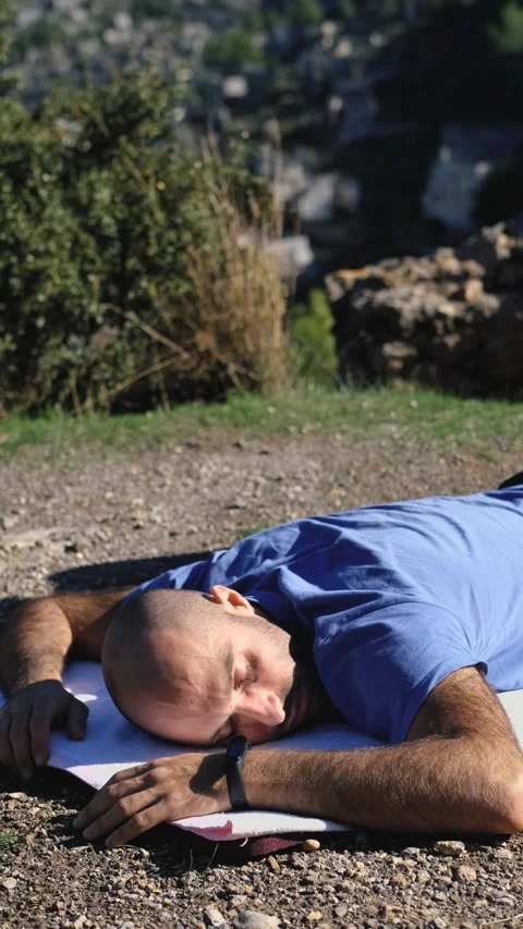 Man resting on a rug in nature, vertical video Video stock 229836467