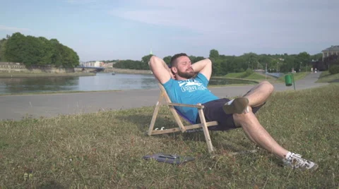 Man is resting on sunbad by the river. 库存影片 65205401