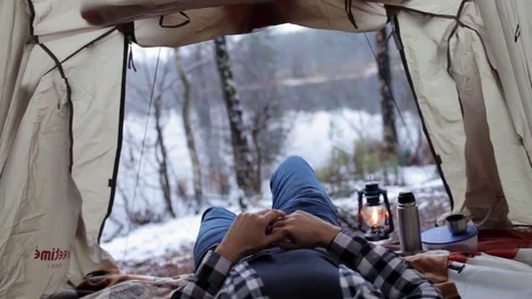 Man is resting in a tent on the shore of a winter lake Stock Footage 83145609