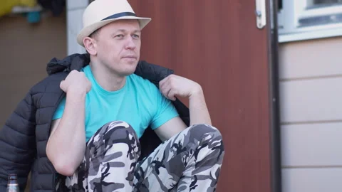 A man is resting while sitting on the porch of his house Stock Footage 154715852