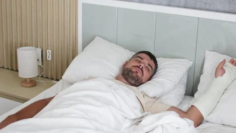 Man rests in bed with broken arm. Stock Footage 290842696