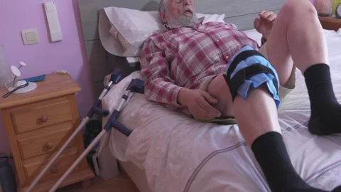 Man rests on bed with leg brace 스톡 동영상 335280200