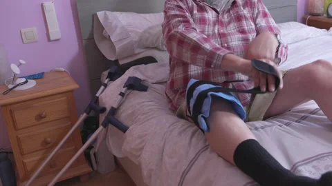 Man rests on bed with leg brace Vídeo Stock 335280239