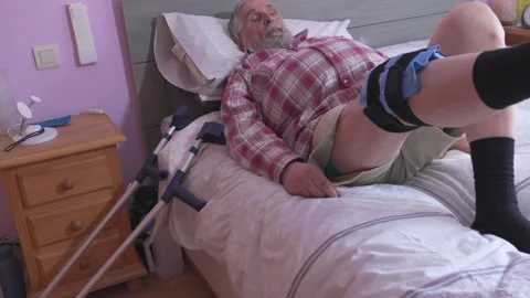 Man rests on bed with leg brace Stock-Footage 335280246