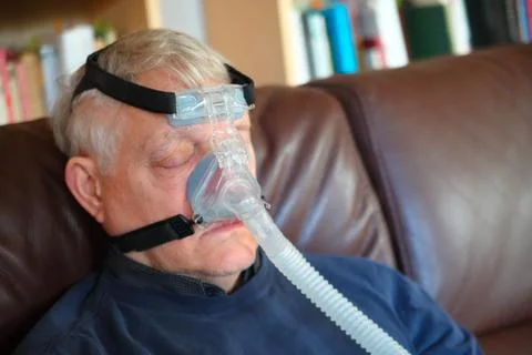 Man rests with CPAP device Stock Photos