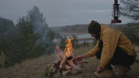 A man rests by a night campfire in the mountains. Stock Footage 220191687