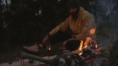 A man rests by a night campfire in the mountains. Stock Footage 220191731