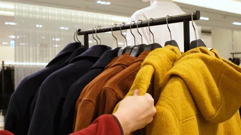A man in a retail mall selects and compares coat, close-up. Stock Footage 167354010
