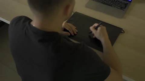 A man is retouching photos on a graphics tablet his hands in close-up shot Stock Footage 232562931