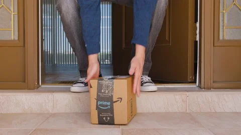 Man retrieving  Amazon prime box delivered to residential porch. Stock Footage 150966869
