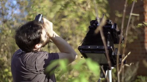Man with retro camera among green trees Stock Footage 72102794