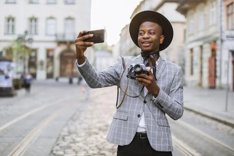 Man with retro camera in hands taking selfie on mobile 库存照片