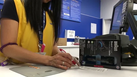 Man returning beard trimmer at customer service counter inside Walmart store Stock Footage 161966484
