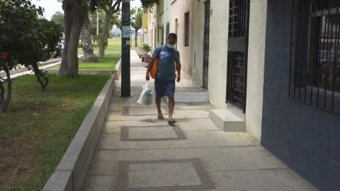 A man returning with the purchases of the house walking with a bag Stock Footage 149900563