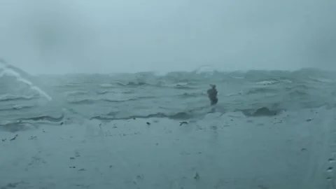 Man returning from stormy swim in rough sea Stock Footage 318686006