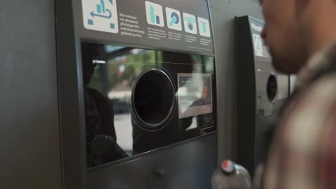 A man returns plastic bottles in a German supermarket. Reverse vending machine Video stock 212373654