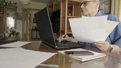 Man Reviewing Documents While Using Laptop at Home Office. Dolly Stock Footage 309098898