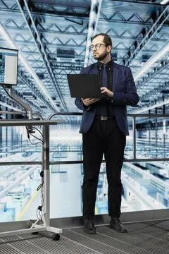 Man reviewing microchips factory analytics using laptop 写真素材