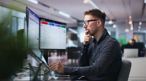 Man Reviews Software Dashboard Using Touchscreen To Track Compliance Risks. Stock Photos