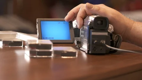 Man rewinds mini DV cassette tape in miniDV video camera camcorder Stock Footage 99485021