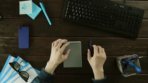 Man rewrites the information from the computer in notebook. Stock Footage 82006704