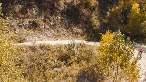 Man ride bicycle on the mountain road shot by drone Vídeos de archivo 139956887