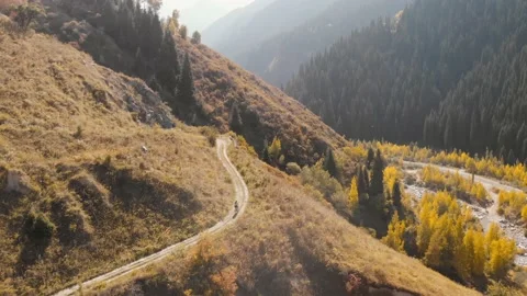 Man ride bicycle on the mountain road shot by drone Stock Footage 139957192